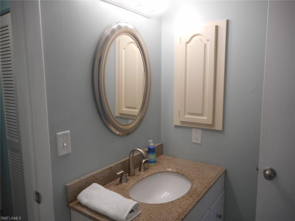 1007 Pine Isle Lane, Unit 1007 Naples, FL 34112 - Photo 10 of 22 a bathroom with a sink and a mirror