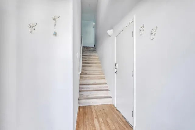 a view of a hallway with wooden floor and entryway