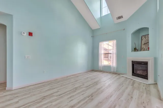 a view of empty room with wooden floor and fireplace