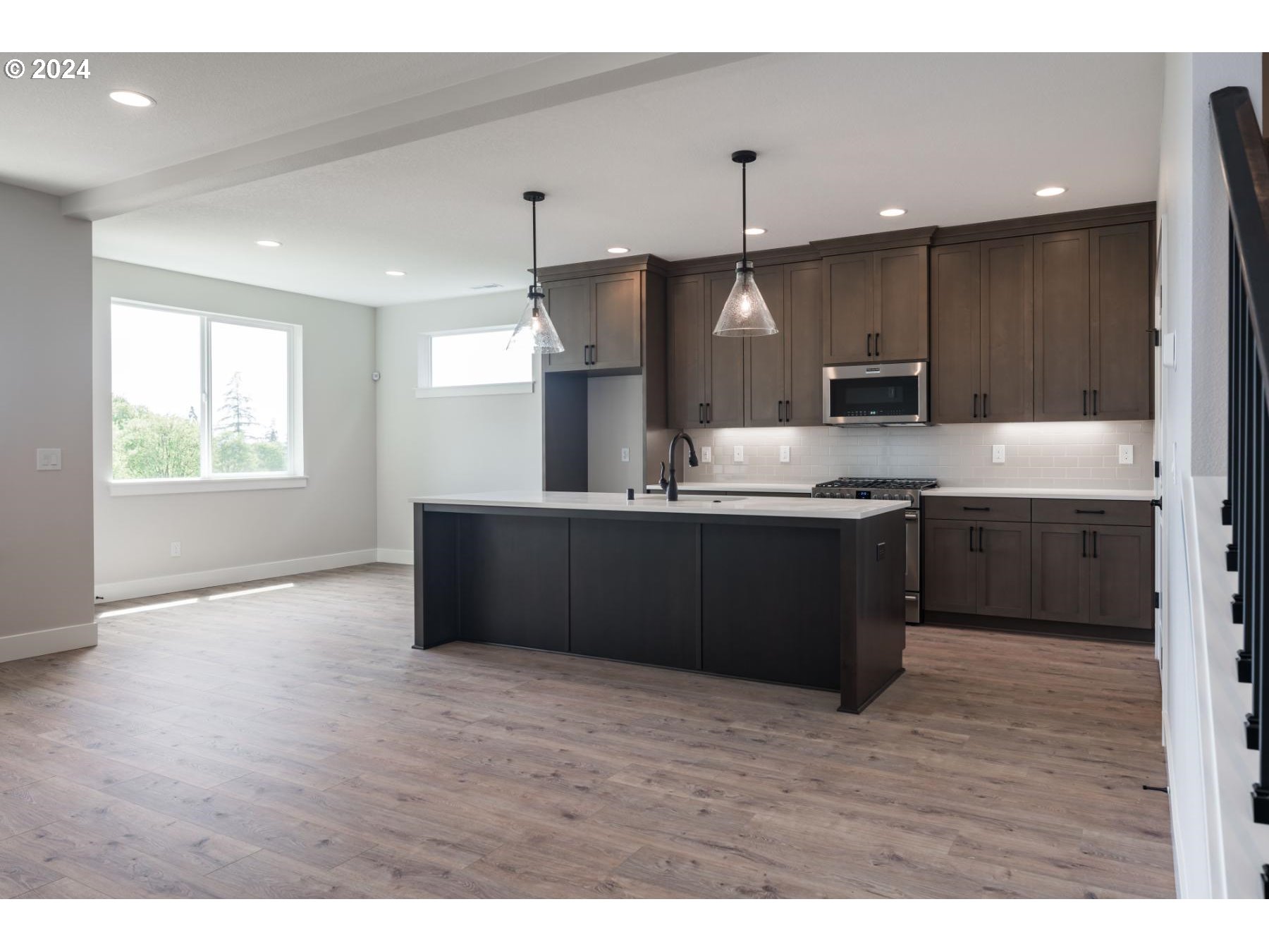 705 Northeast 174th Street Ridgefield, WA 98642 - Photo 6 of 13 a kitchen with kitchen island stainless steel appliances a sink counter space and wooden floor
