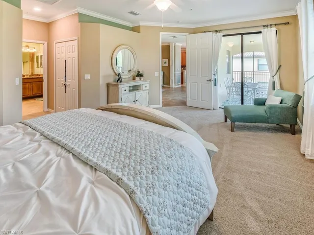 a spacious bedroom with a bed a dresser and a large window