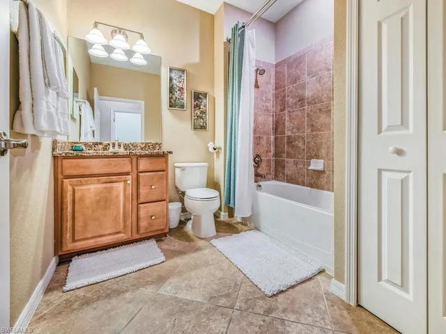 a spacious bathroom with a granite countertop sink mirror vanity bathtub and a toilet