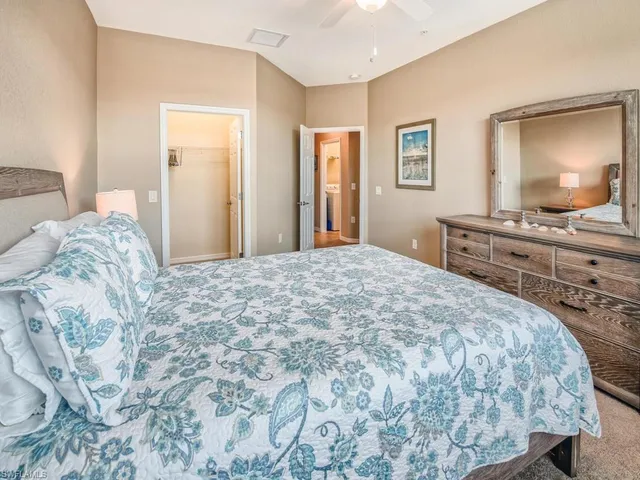 a bedroom with a large bed and a flat tv screen on dresser