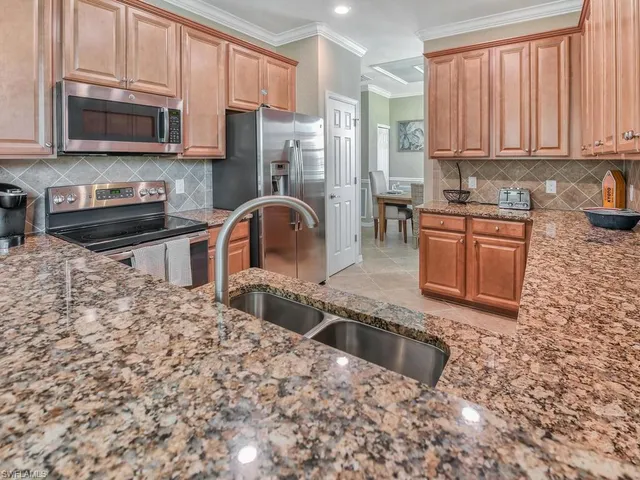 a kitchen with stainless steel appliances granite countertop a stove a sink a microwave and a refrigerator