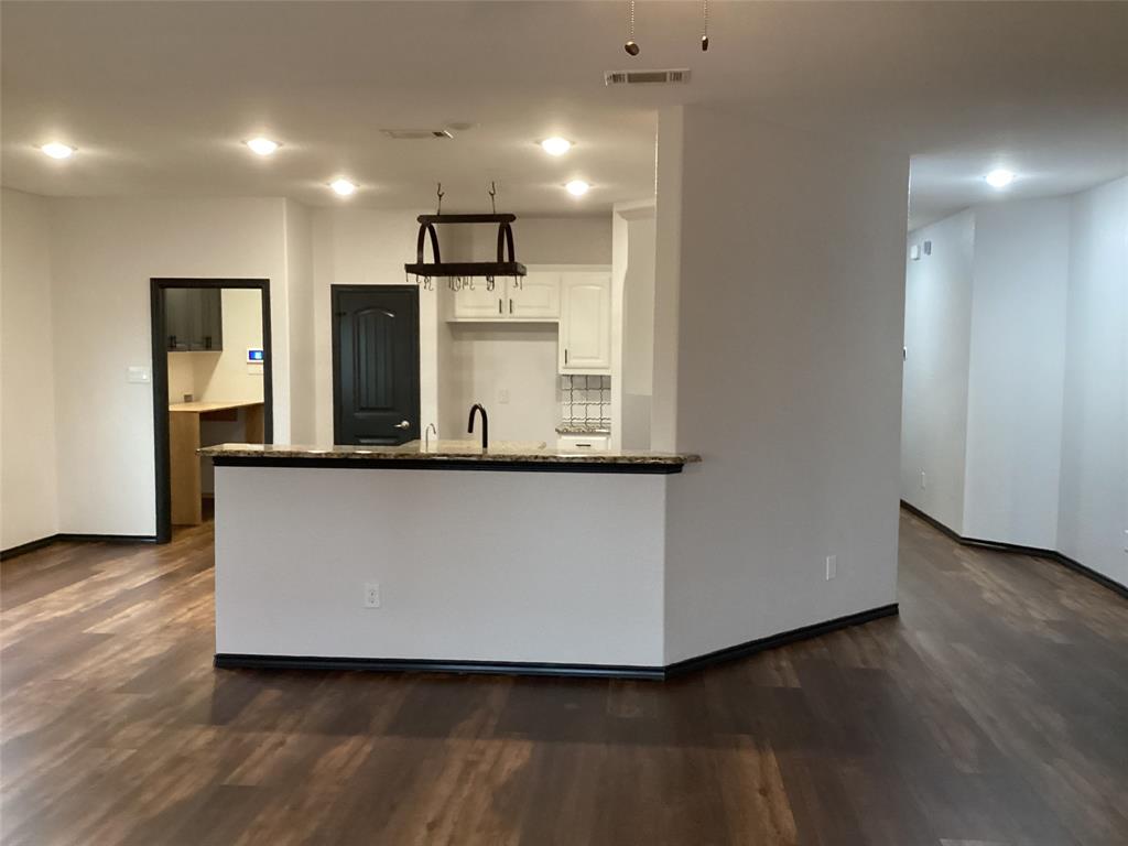 10320 Point Lobos Trail Fort Worth, TX 76177 - Photo 10 of 33 Open-concept living space with wood-finish flooring, recessed lighting, and a kitchen island featuring a granite-style countertop