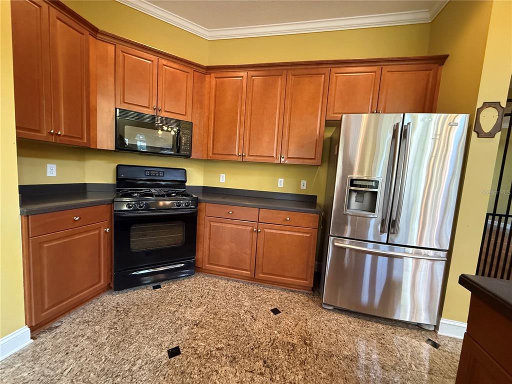 800 North End Street St. Augustine, FL 32095 - Photo 22 of 52 a kitchen with granite countertop a refrigerator and a stove top oven