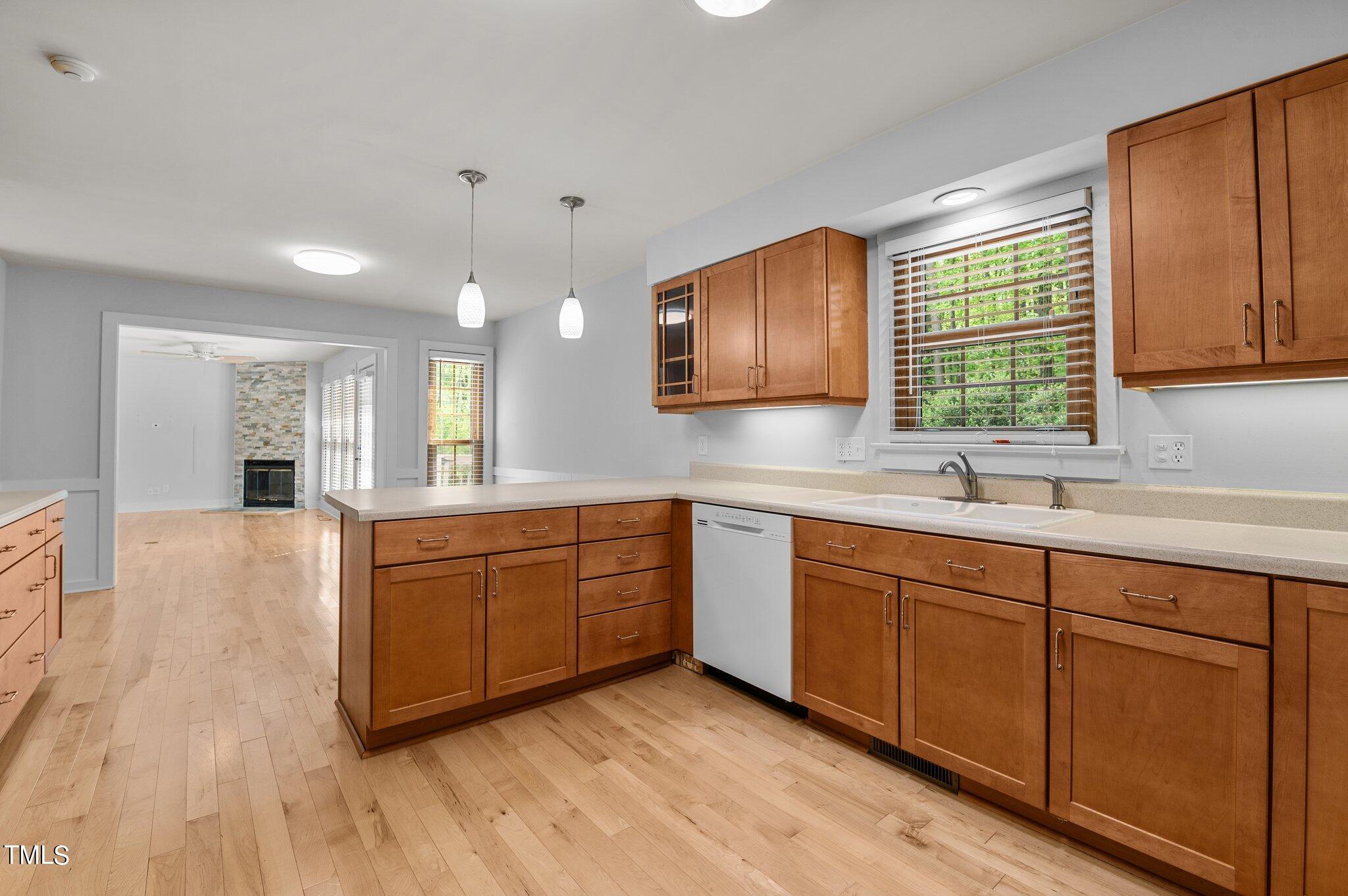 1901 Nipper Road Raleigh, NC 27614 - Photo 14 of 57 a large kitchen with stainless steel appliances granite countertop a sink dishwasher a stove a dining table and chairs with wooden floor