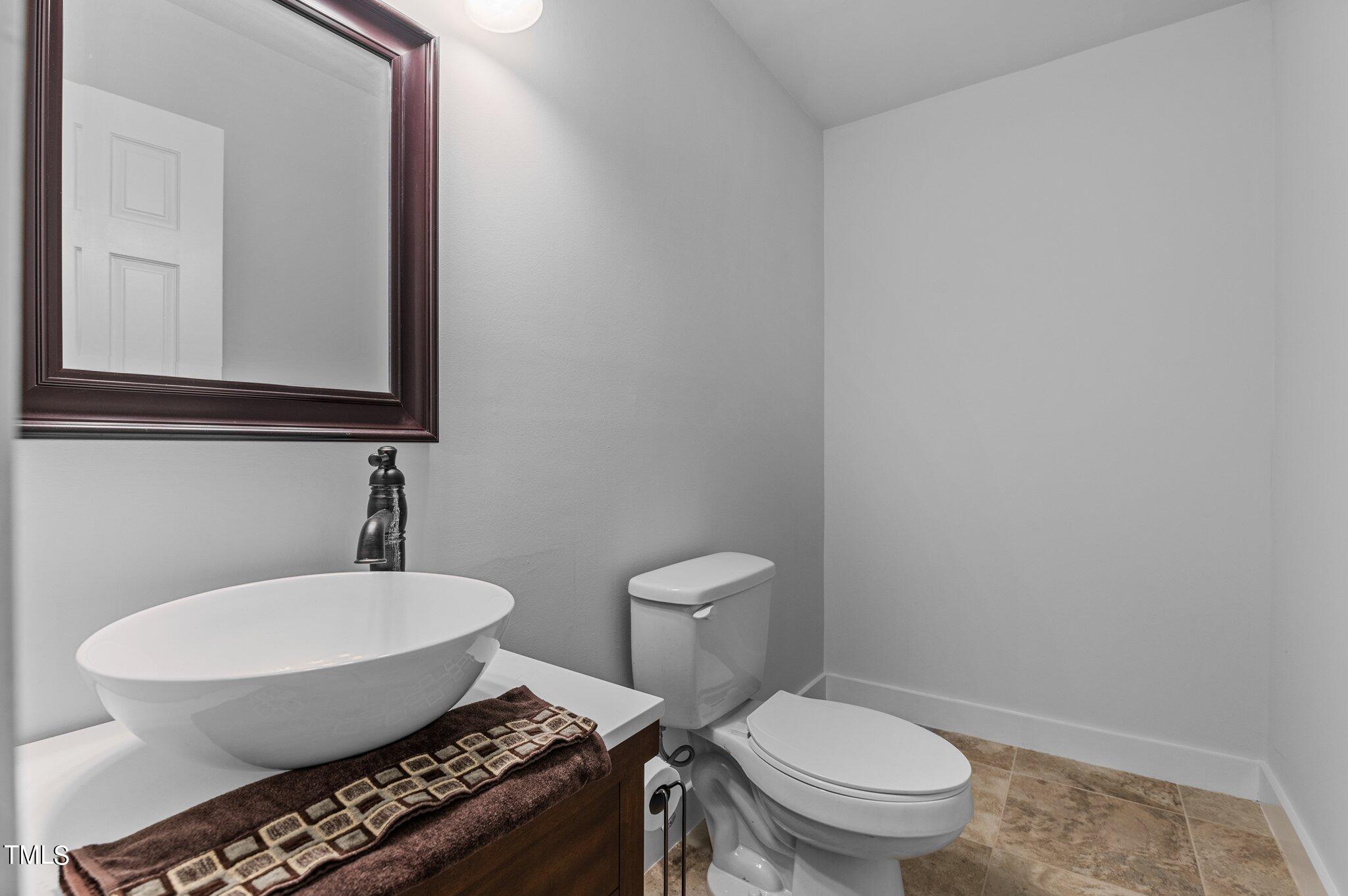 1901 Nipper Road Raleigh, NC 27614 - Photo 36 of 57 a bathroom with a toilet a sink and mirror