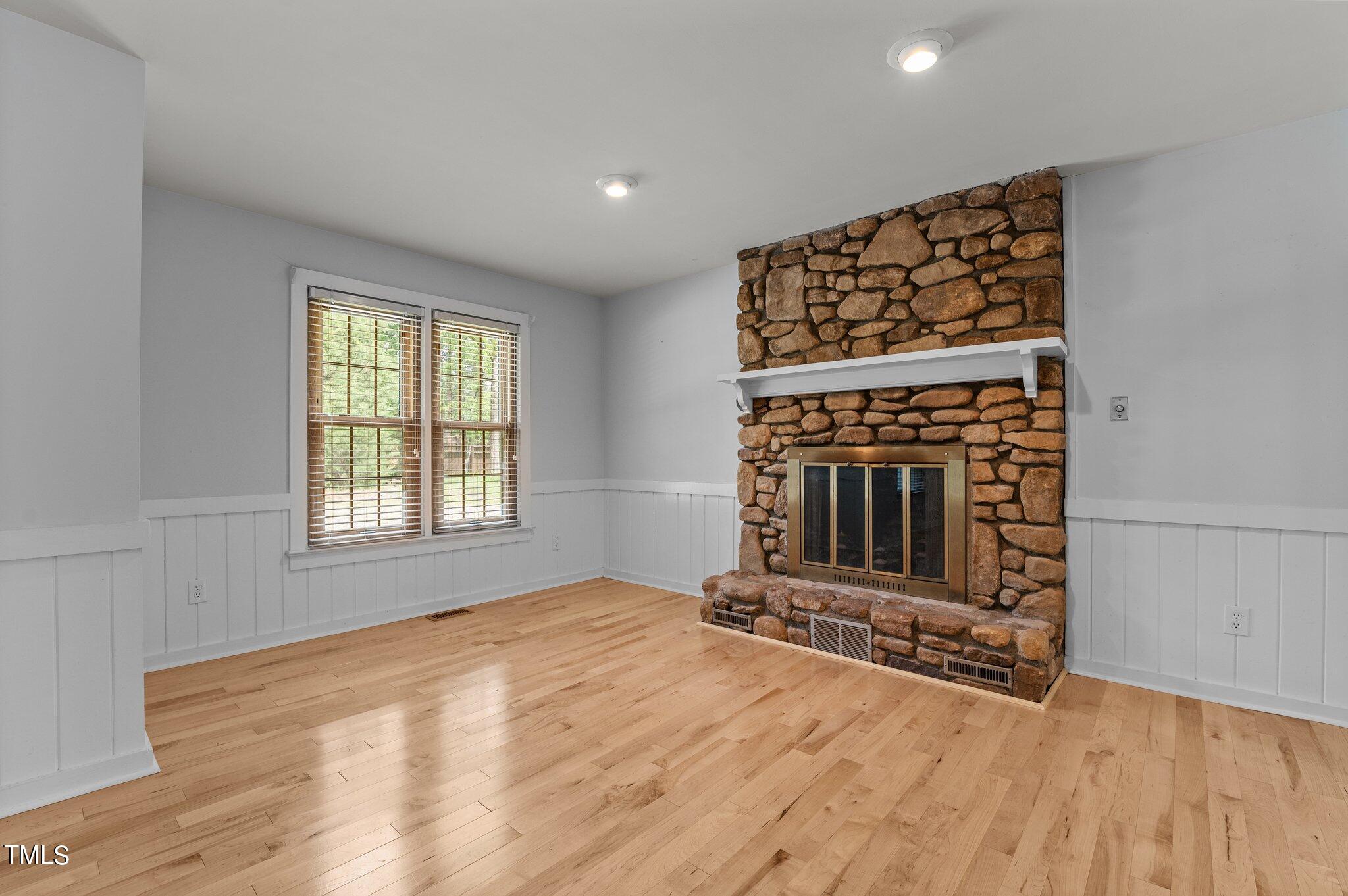 1901 Nipper Road Raleigh, NC 27614 - Photo 8 of 57 a view of an empty room with wooden floor fireplace and a window