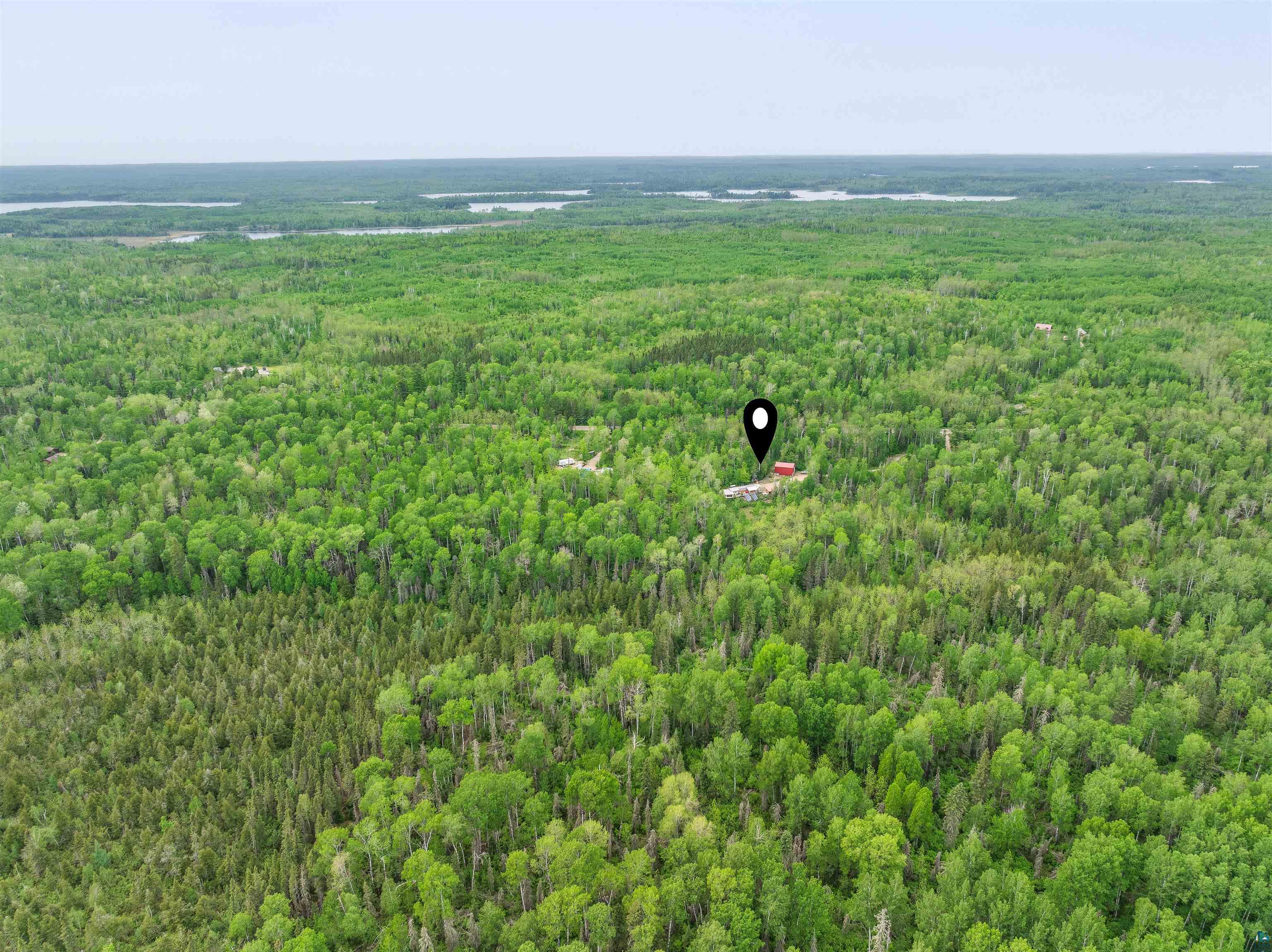 1152 Fernberg Road Ely, MN 55731 - Photo 24 of 24 Expansive forested landscape featuring a distant red-roofed structure