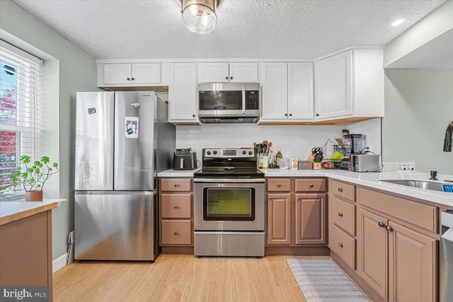 a kitchen with stainless steel appliances a refrigerator stove and sink