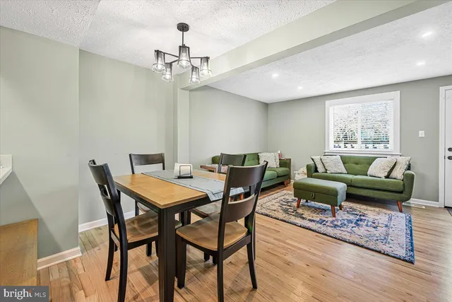 a view of a dining room with furniture a chandelier and wooden floor