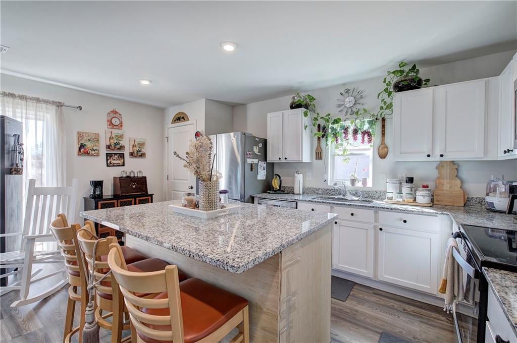 635 Tudor Street Euharlee, GA 30145 - Photo 18 of 39 a kitchen with granite countertop kitchen island white cabinets and refrigerator