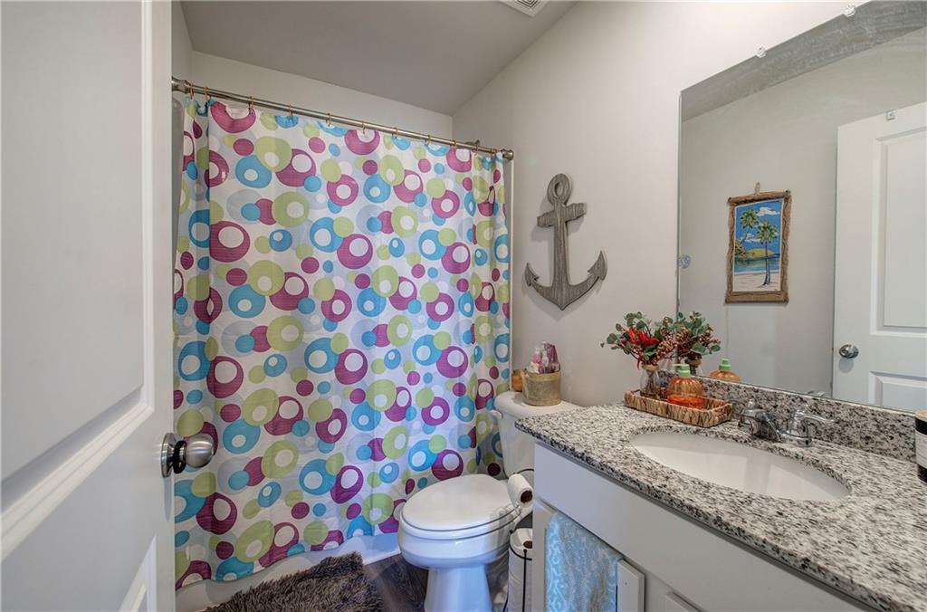 635 Tudor Street Euharlee, GA 30145 - Photo 31 of 39 a bathroom with a granite countertop sink a toilet and a shower curtain