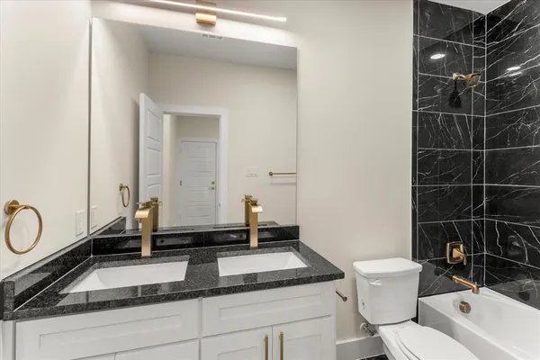 a bathroom with a sink a toilet and a mirror