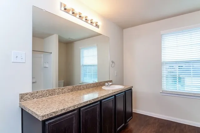a bathroom with a granite countertop sink and a mirror