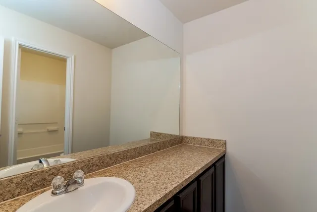 a bathroom with a granite countertop sink and a mirror