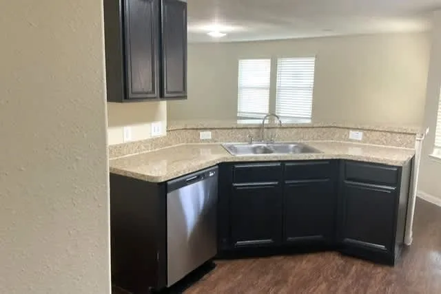 a kitchen with granite countertop a sink and cabinets