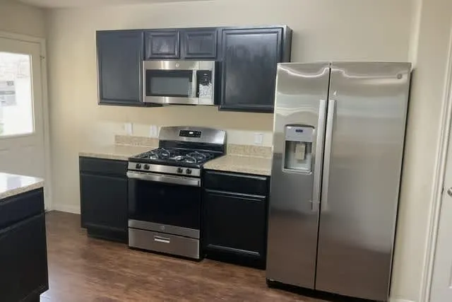 a kitchen with a refrigerator stove and microwave