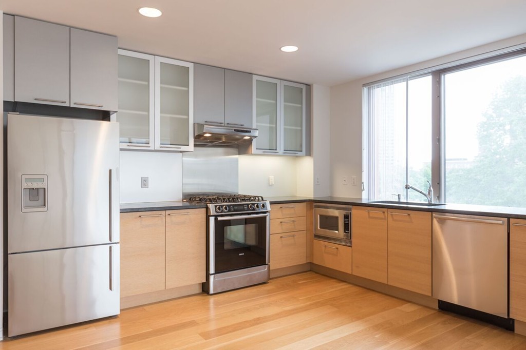 303 Third Street, Unit 417 Cambridge, MA 02142 - Photo 4 of 22 a kitchen with stainless steel appliances granite countertop a refrigerator sink and stove