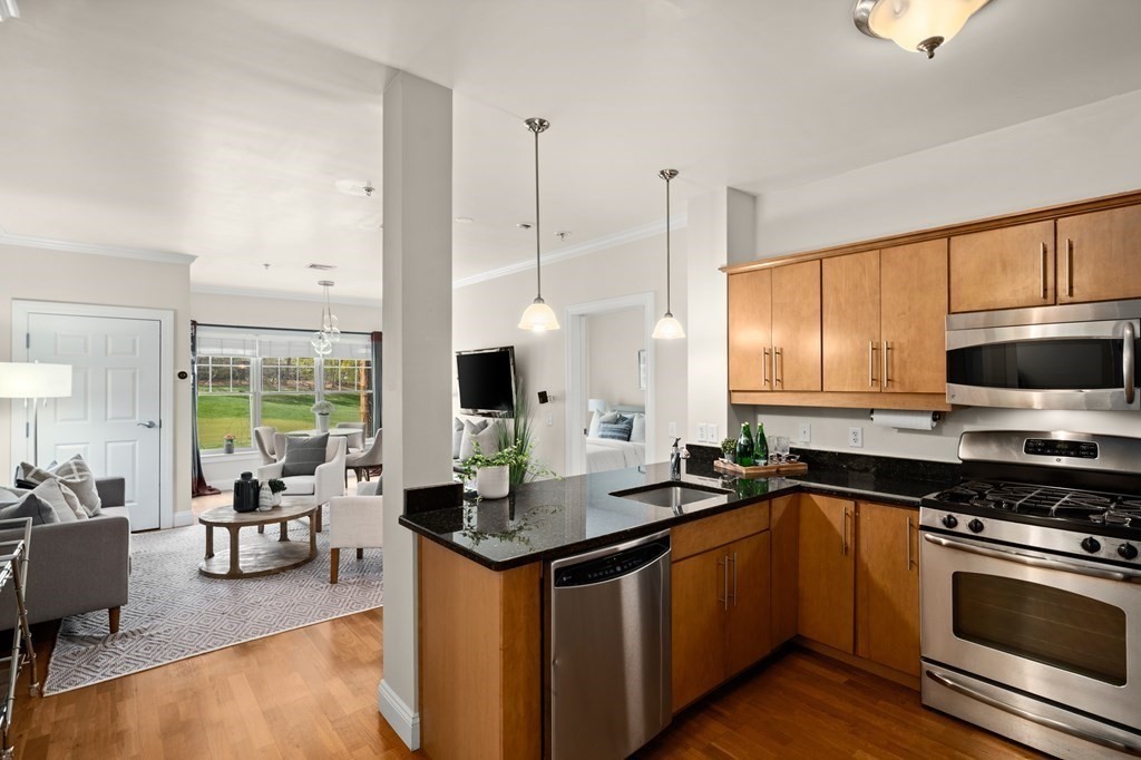35 Commonwealth Avenue, Unit 103 Newton, MA 02467 - Photo 2 of 23 a kitchen with stainless steel appliances granite countertop a sink stove and cabinets