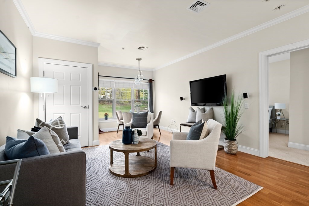 35 Commonwealth Avenue, Unit 103 Newton, MA 02467 - Photo 3 of 23 a living room with furniture and a flat screen tv