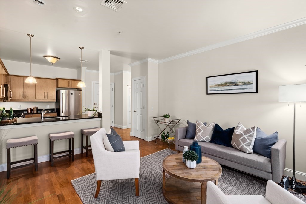 35 Commonwealth Avenue, Unit 103 Newton, MA 02467 - Photo 4 of 23 a living room with furniture kitchen view and a table