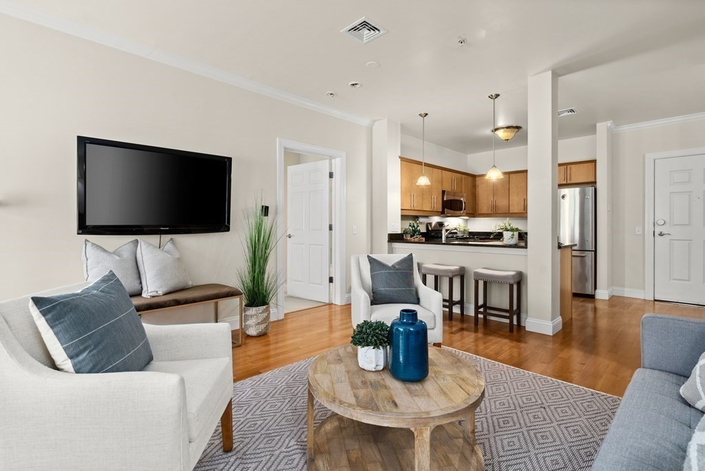 35 Commonwealth Avenue, Unit 103 Newton, MA 02467 - Photo 5 of 23 a living room with furniture and a flat screen tv