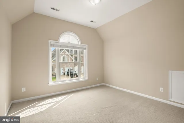 a view of an empty room with wooden floor and closet