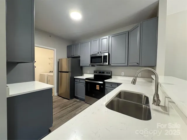 a kitchen with stainless steel appliances granite countertop a refrigerator sink and stove