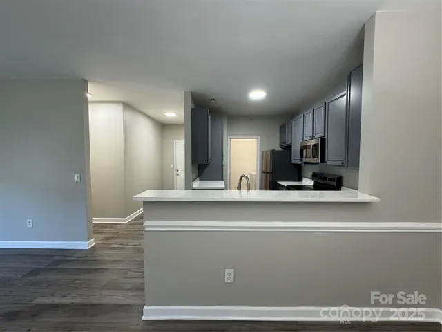 a view of kitchen with stainless steel appliances granite countertop refrigerator sink and cabinets