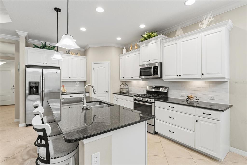 11610 Marathon Circle Venice, FL 34293 - Photo 11 of 84 a kitchen with granite countertop a sink stainless steel appliances and cabinets