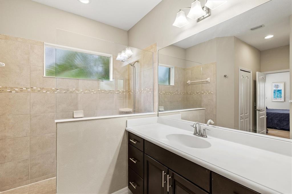 11610 Marathon Circle Venice, FL 34293 - Photo 23 of 84 a bathroom with a sink a large mirror and a shower