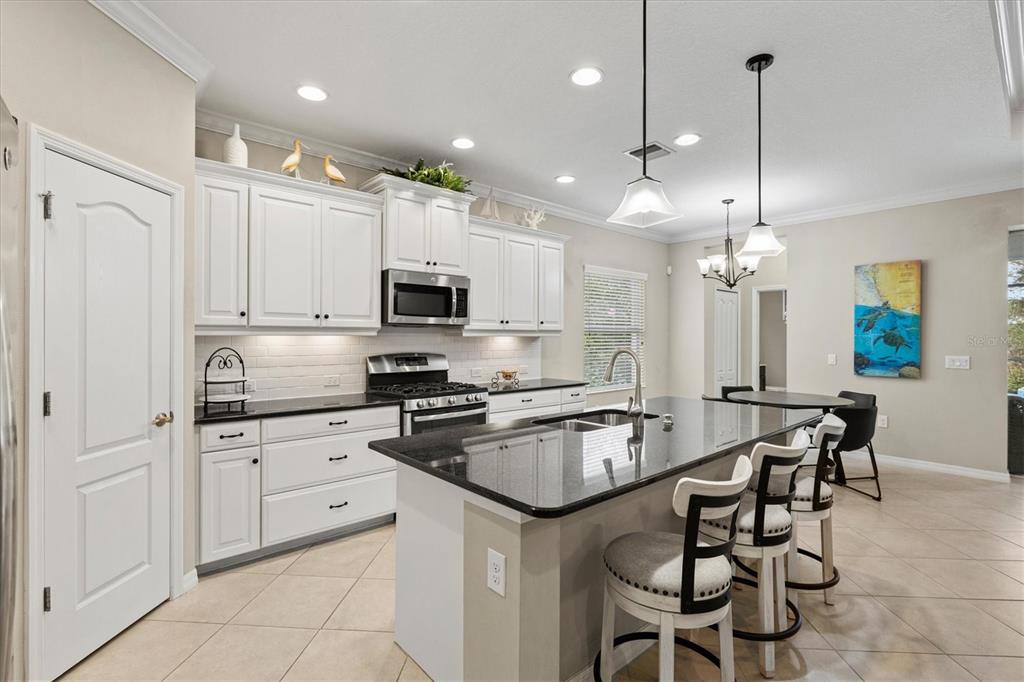 11610 Marathon Circle Venice, FL 34293 - Photo 25 of 84 a kitchen with stainless steel appliances a stove a sink island and a refrigerator