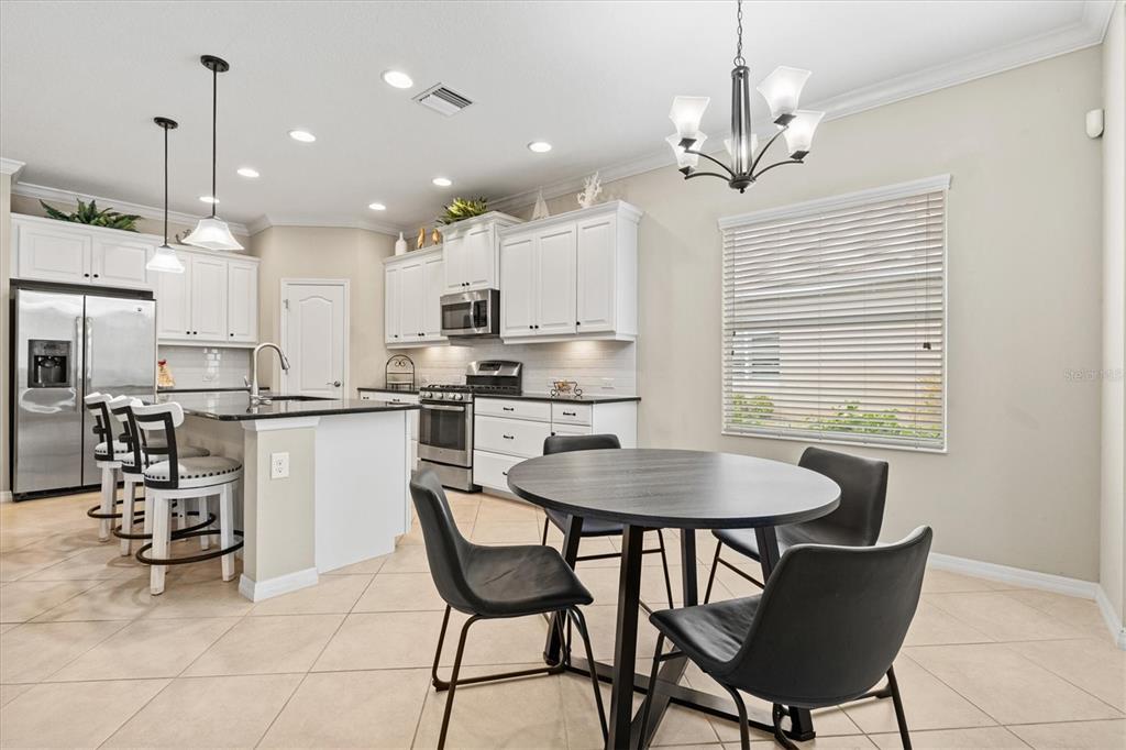 11610 Marathon Circle Venice, FL 34293 - Photo 10 of 84 a kitchen with kitchen island a dining table and chairs