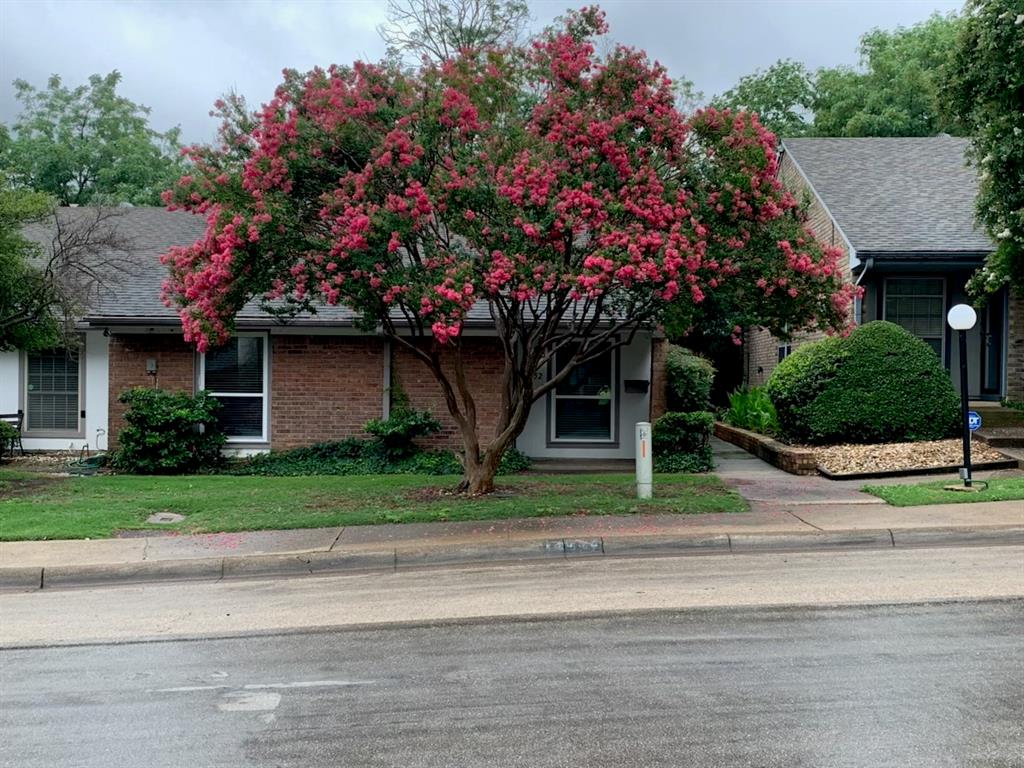 13652 Flagstone Lane Dallas, TX 75240 - Photo 1 of 15 View of property hidden behind natural elements featuring brick siding and roof with shingles