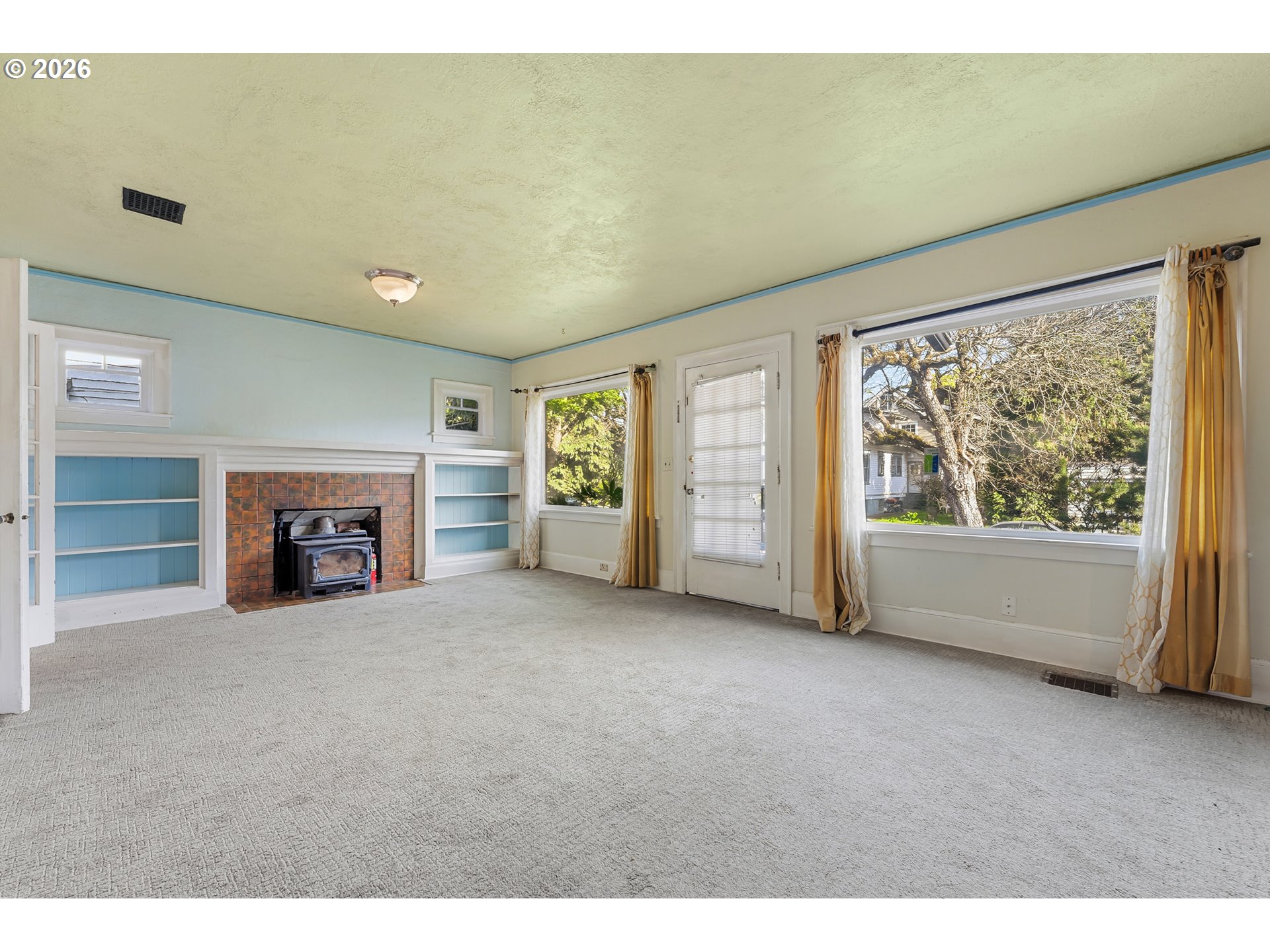 2714 Northeast Everett Street Portland, OR 97232 - Photo 4 of 6 a view of an empty room with a fireplace and a window