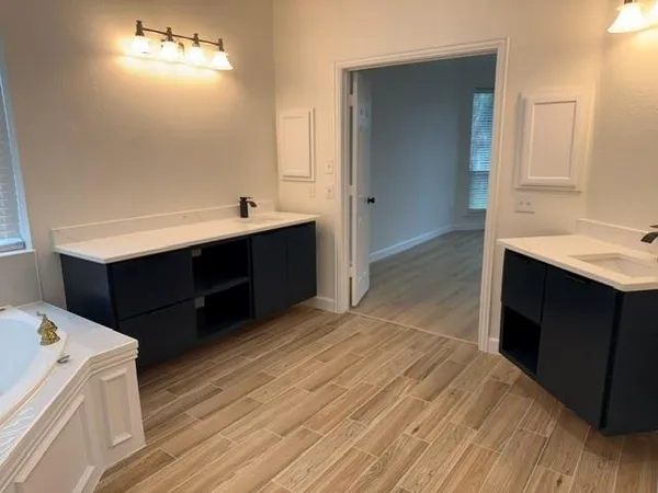 a view of empty room with wooden floor and window