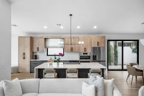 a living room with stainless steel appliances kitchen island granite countertop furniture and a large window