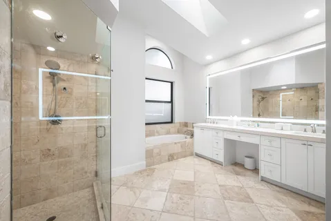 a large bathroom with a glass door shower a sink and a mirror