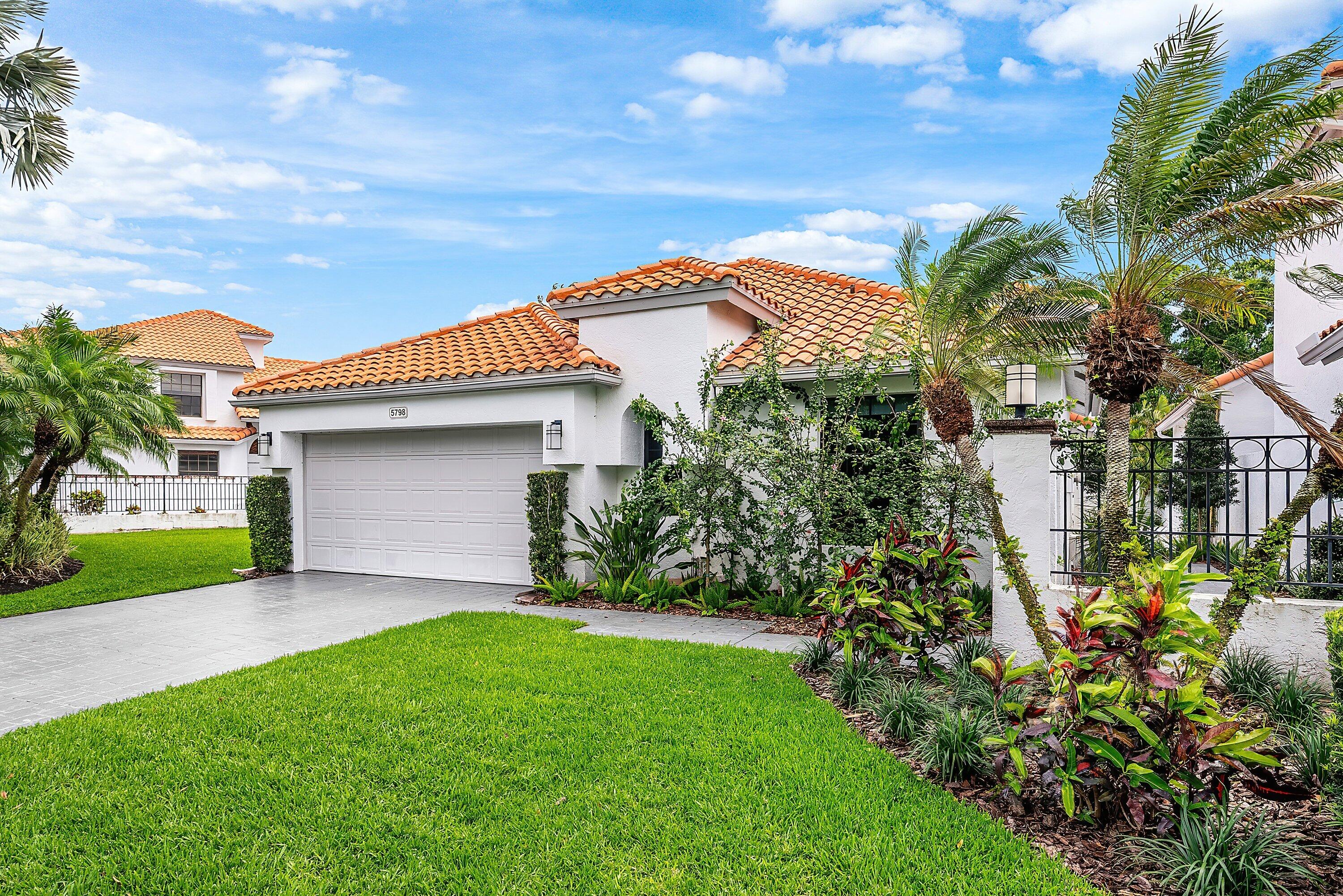 5798 Northwest 21st Avenue Boca Raton, FL 33496 - Photo 2 of 52 a front view of a house with a garden and plants