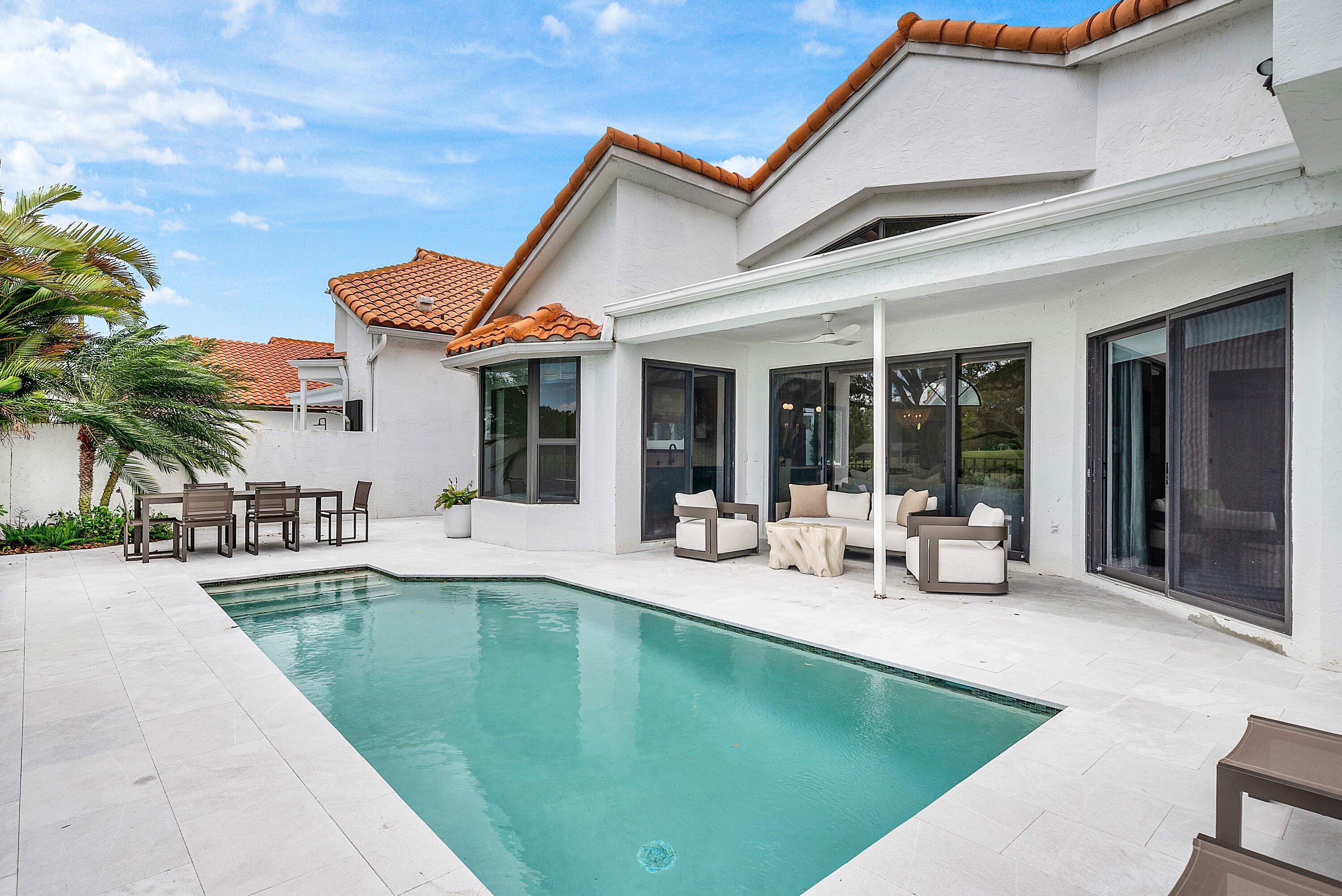 5798 Northwest 21st Avenue Boca Raton, FL 33496 - Photo 25 of 52 a view of a patio with swimming pool table and chairs