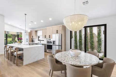 a kitchen with stainless steel appliances granite countertop a table chairs and mountain view