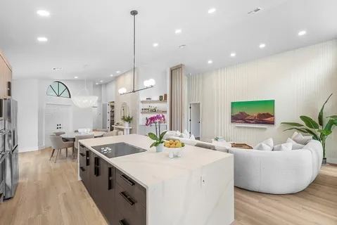 a very nice looking living room with a dining table chairs and a potted plant