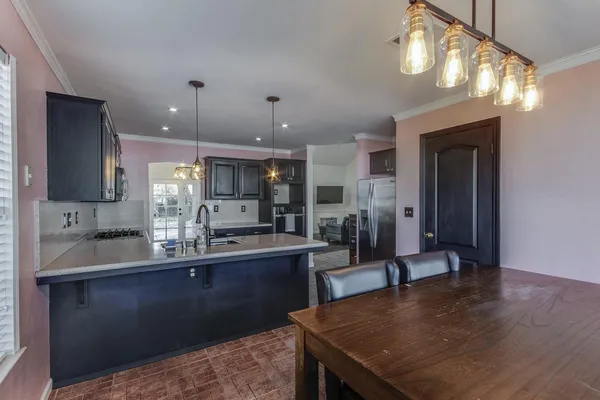 a kitchen with stainless steel appliances granite countertop a sink counter space cabinets and wooden floor