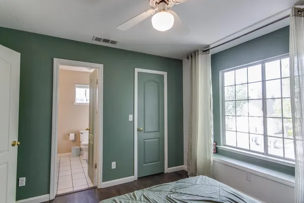 a view of an empty room with bathroom and a window