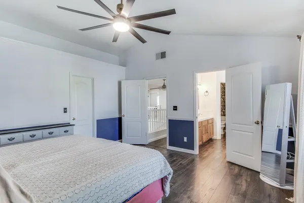 a spacious bedroom with a bed and a dresser