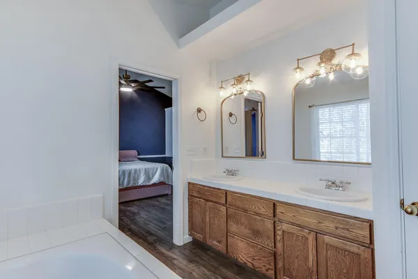 a spacious bathroom with a double vanity sink a mirror and a shower