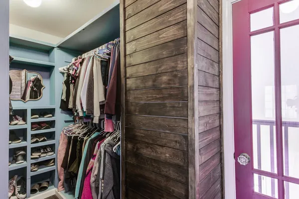 a view of walk in closet with clothes and shoes
