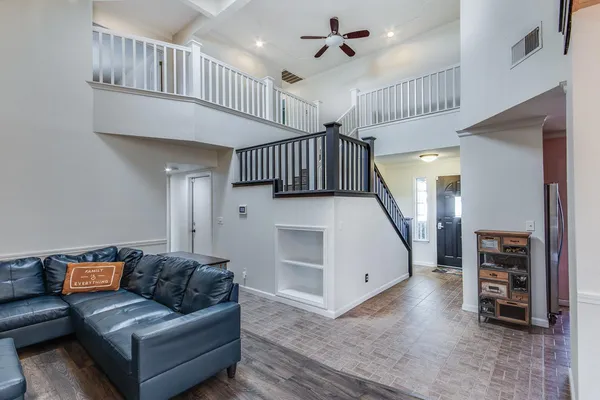 a living room with furniture and a wooden floor